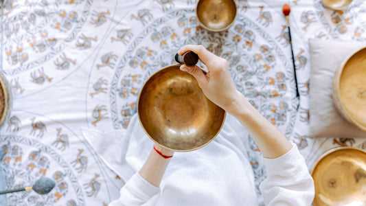 birds eye view of a woman playing a singing sound bowl with a mallet